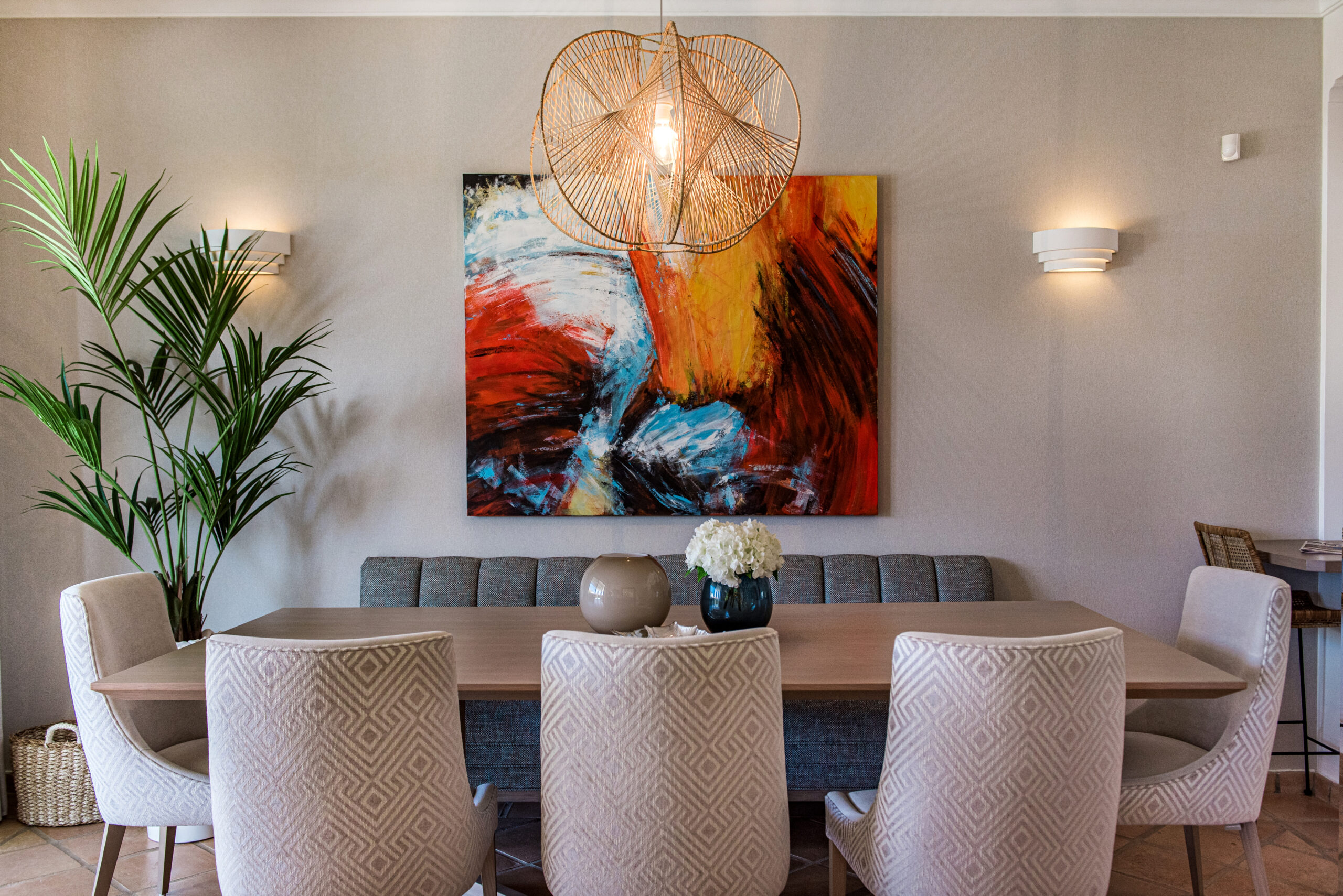 Red abstract-themed dining room with natural elements: A striking dining room featuring a wood dining table and chairs amidst a vibrant red abstract backdrop. The combination of natural elements and bold color creates a captivating and modern dining experience.